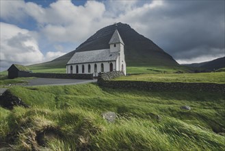 Green landscape with rural church and mountain