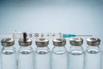 Row of Covid-19 vaccine vials and syringe