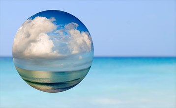 Sea and sky reflected in glass sphere