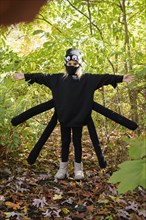 Girl (8-9) wearing Halloween costume in forest