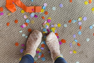 Human feet on floor with confetti