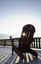 Adirondack chair on deck by lake