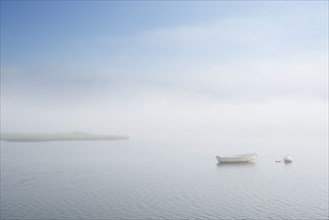 Dinghy on foggy lake