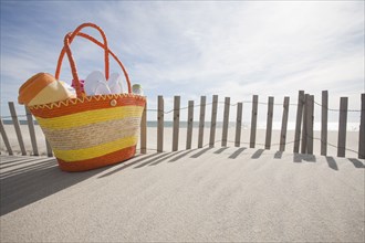 Beach bag with flip-flops on beach