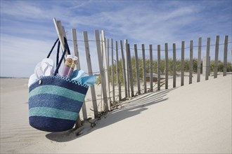 Beach bag with flip-flops on beach