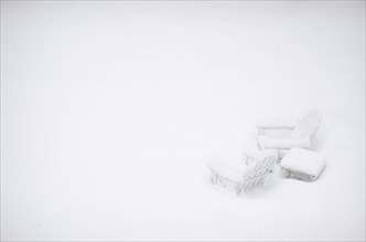 Outdoor chairs and table covered with snow