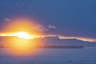 Sun setting over mountains and prairie