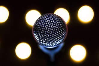 Close-up of microphone with stage lights in background