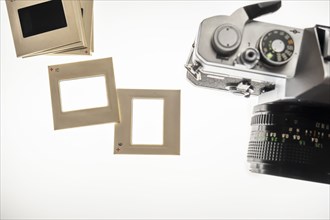 Studio shot of blank slide film transparencies on lightbox and 35mm camera