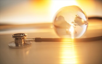 Stethoscope and glass globe in sunlight