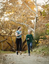 Boy and girl running on footpath in forest