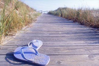 Flip flops on boardwalk to beach