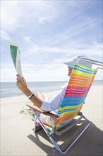 Woman reading magazine on beach