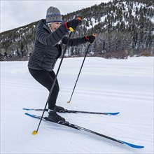 Senior woman cross - country skiing on groomed trails