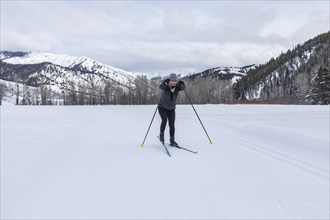 Senior woman cross - country skiing on groomed trails