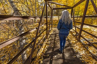 Woman walking across footbridge over Big Wood River