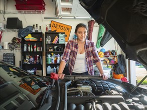 Woman fixing car in garage