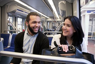 Young couple traveling on light train