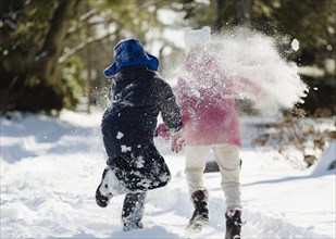 Two children running in snow