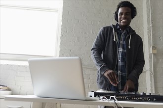 DJ using laptop and mixing desk