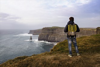Mid adult man standing on The Cliffs of Moher