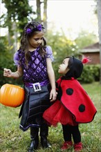 Two girls with trick or treat bucket
