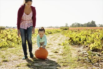Mother and daughter in pumpkin field