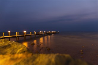 View of sea and pier at night
