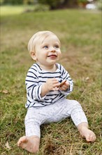 Portrait of baby girl sitting on grass