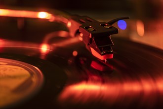 Close-up of a record player needle on record in red light