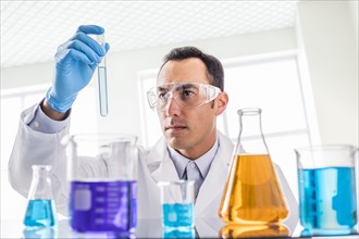 Scientist looking at blue liquid in laboratory