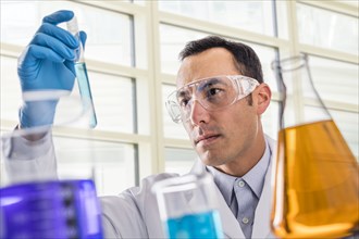 Scientist looking at blue liquid in laboratory