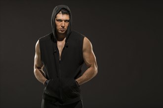 Portrait of muscular man in hooded vest