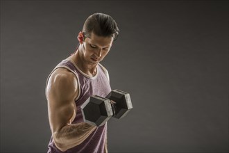 Muscular man doing bicep curl with dumbbell