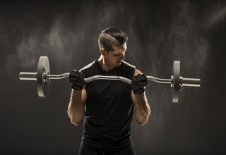 Muscular man training with barbell