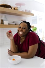 Smiling woman eating red peppers