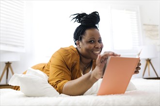 Smiling woman reading book in bed