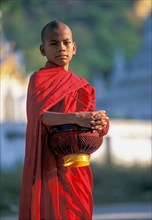 Buddhist monk holding bowls during morning alms