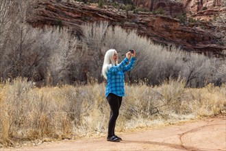 Woman taking pictures while hiking in Grand Staircase-Escalante National Monument