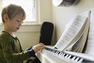 Boy (6-7) playing piano