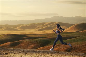 Woman jogging in landscape at sunset