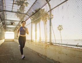Woman jogging near beach at sunset