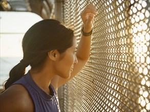Athlete woman resting at fence