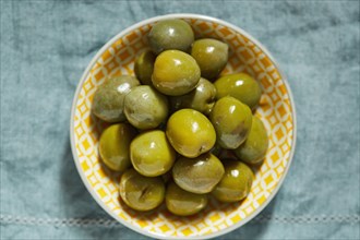 Overhead view of green olives in bowl