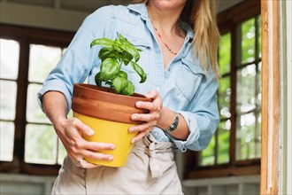 Woman holding potted basil