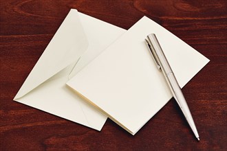 Envelope and pen on wooden table
