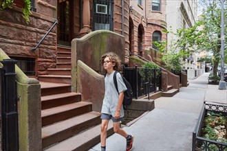 USA, New York, New York City, Boy walking in residential district