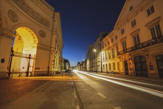 Poland, Masovia, Warsaw, Illuminated city street with historical buildings at night