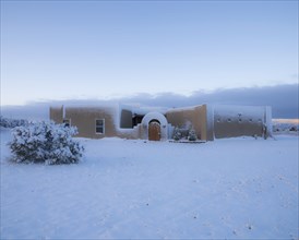 Usa, New Mexico, Santa Fe, Adobe style house covered with snow in winter