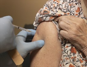 Close-up of senior woman receiving dose of Covid-19 vaccine